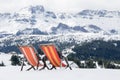 two colored deckchairs are installed on the fresh snow Royalty Free Stock Photo